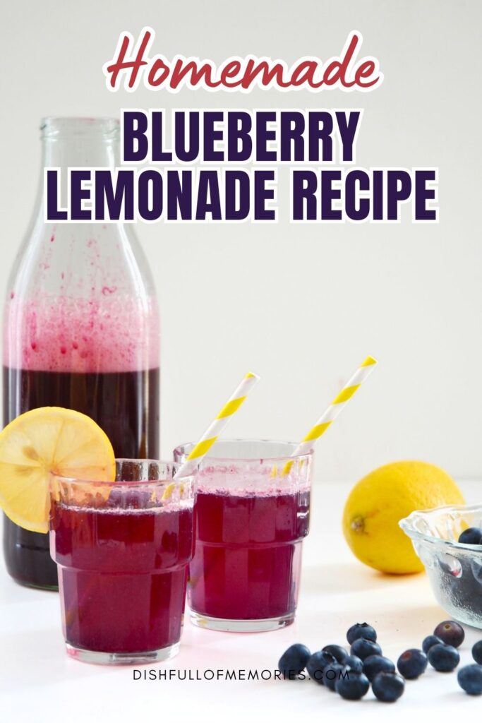 Bottle of blueberry lemonade with two filled glasses and lemons and blueberries next to them on the table. Text on image: Homemade blueberry lemonade recipe. Dish full of memories dot com.
