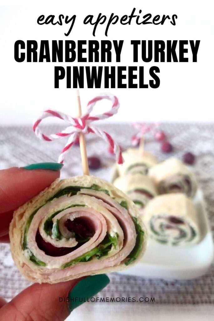 Hand holding up a tortilla roll up. Text on image: easy appetizer. Cranberry Turkey Pinwheels. Dish full of memories dot com.