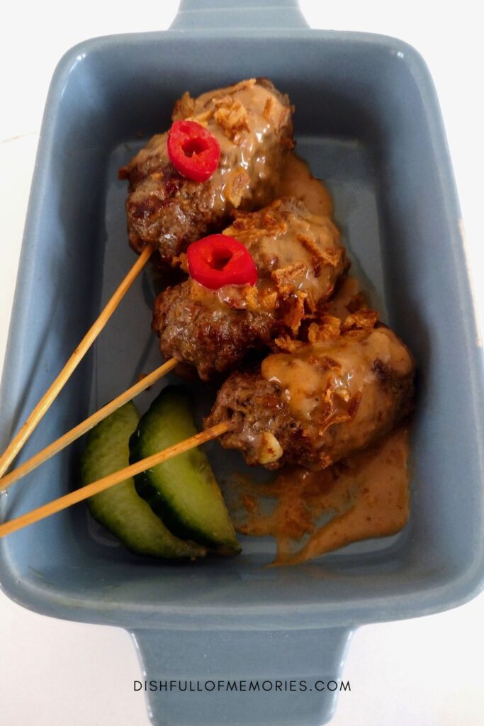 Satay Lilit in blue dish on regular bamboo skewers instead of lemongrass stalks.