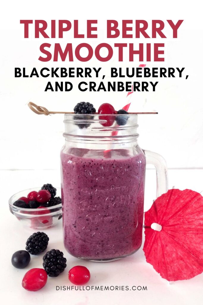 Purple drink in mason jar with berries around. Text on image: Triple berry smoothie. Blackberry, blueberry, and cranberry. Dish full of memories dot com.