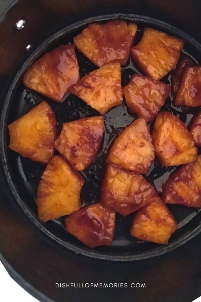 Pineapple chunks being caramelized in the air fryer.