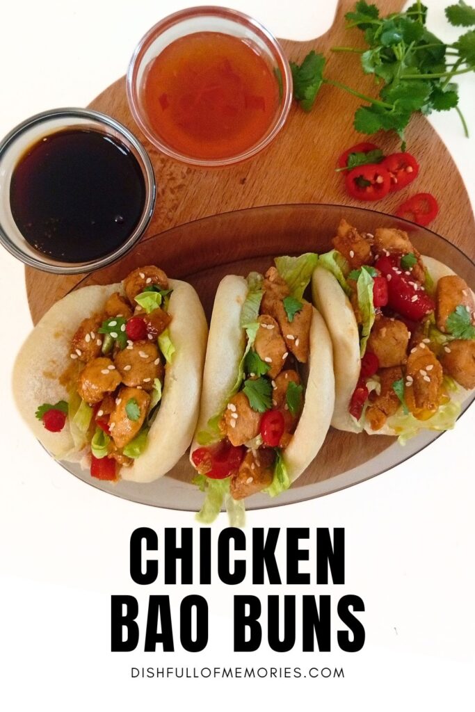 Three homemade asian bao buns on a round serving tray with cilantro and two dipping sauces next to it. Text on image: Chicken bao buns. Dish full of memories dot com.